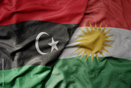 big waving national colorful flag of kurdistan and national flag of libya .