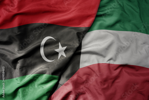 big waving national colorful flag of kuwait and national flag of libya .