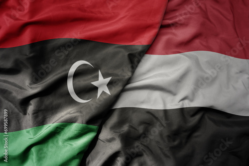 big waving national colorful flag of yemen and national flag of libya .