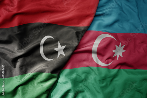 big waving national colorful flag of azerbaijan and national flag of libya .