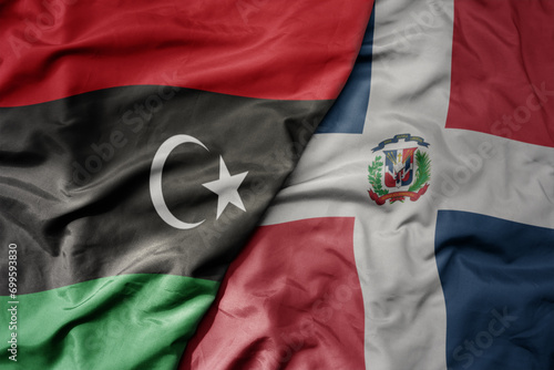 big waving national colorful flag of dominican republic and national flag of libya .