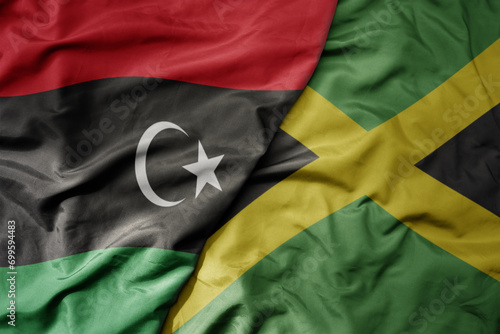 big waving national colorful flag of jamaica and national flag of libya .