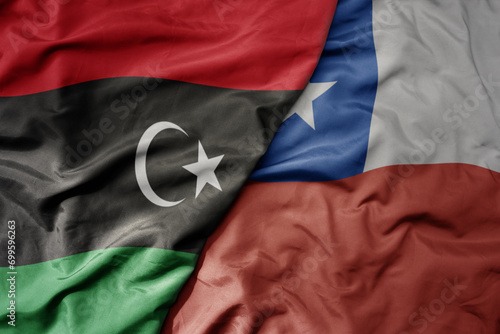 big waving national colorful flag of chile and national flag of libya .