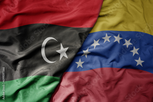 big waving national colorful flag of venezuela and national flag of libya .