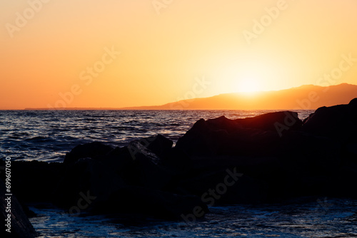 Sunset behind the rocks on the beach