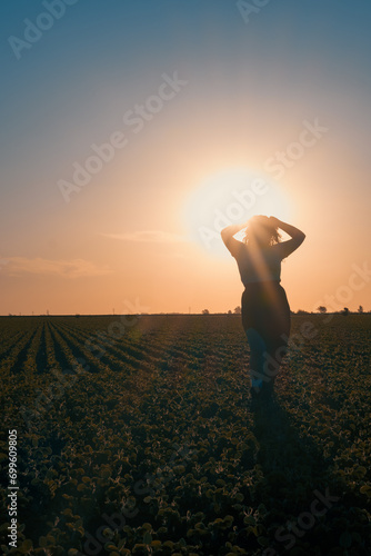 Mujer posando en el campo con cultivos durante el atardecer photo