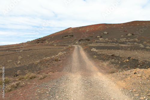Country road in a volcanic landscape in Los Ajaches National Park near Papagayo. Playa Blanca, Lanzarote, Spain. Tourism and vacations concept. 