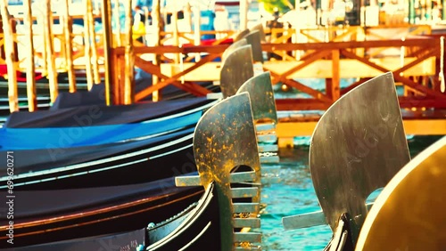 Venetian gondola nose ornaments close-up swinging on water in sunset 4k