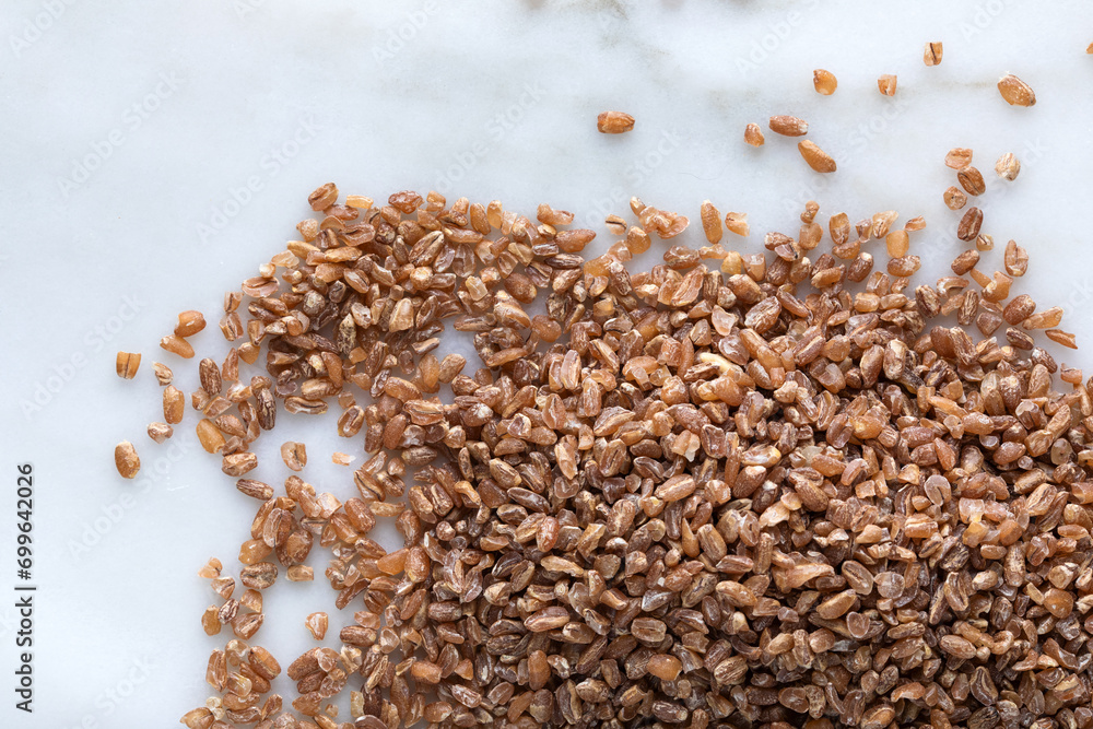 Close up of wheat grains on white marble background. Healthy food concept. Close up of wheat grains on white marble background. Healthy food concept.