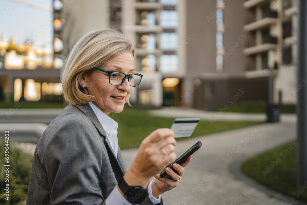 One woman use mobile phone smartphone shopping online in the city One woman use mobile phone smartphone shopping online in the city