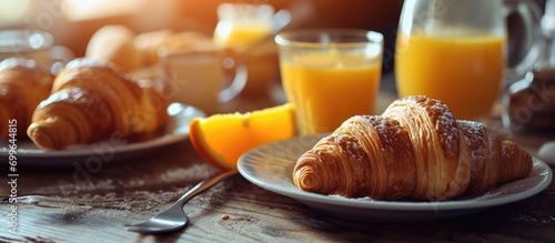 Selective focus on continental breakfast featuring fresh croissants, orange juice, and coffee. photo