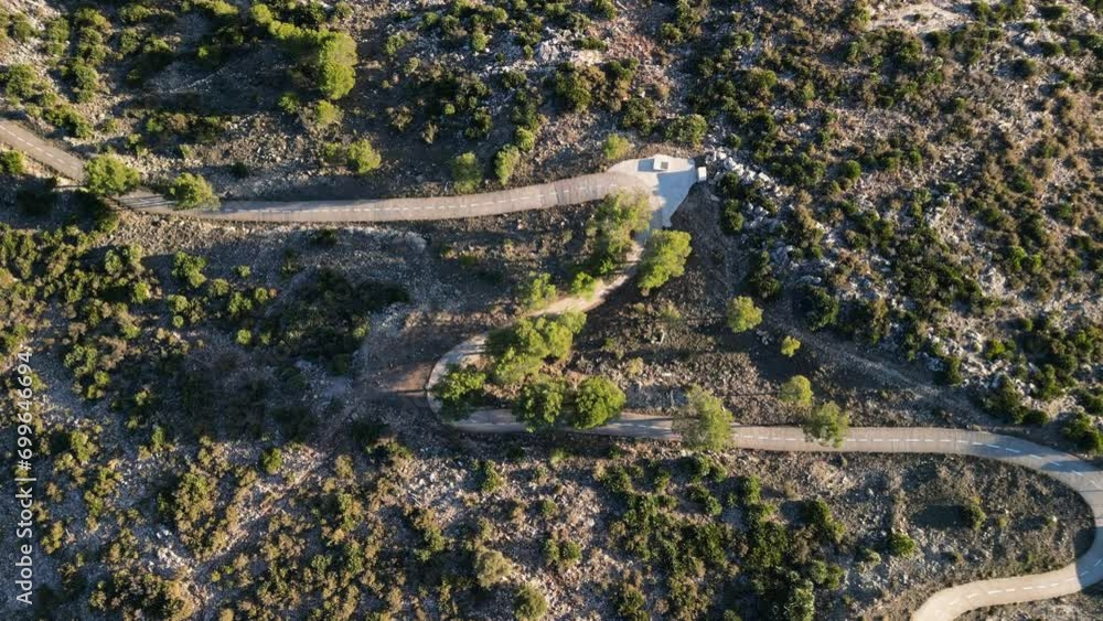 Aerial view of a woman cyclist riding downhill. Cinematic training on carbon road bike. Speedy downhill from mountain on bicycle. Cycling in the mountains of Spain. Aerial view of a woman cyclist riding downhill. Cinematic training on carbon road bike. Speedy downhill from mountain on bicycle. Cycling in the mountains of Spain.