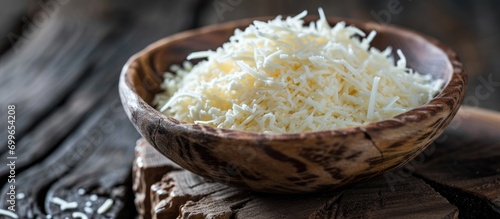 Mozzarella cheese shredded in wooden bowl.