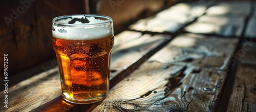 Close-up view of a pint of freshly brewed beer on an old wooden table.