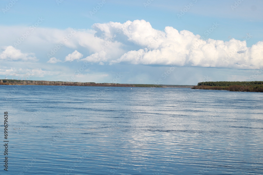 the river is large blue water blue sky with a large white cloud the river is large blue water blue sky with a large white cloud