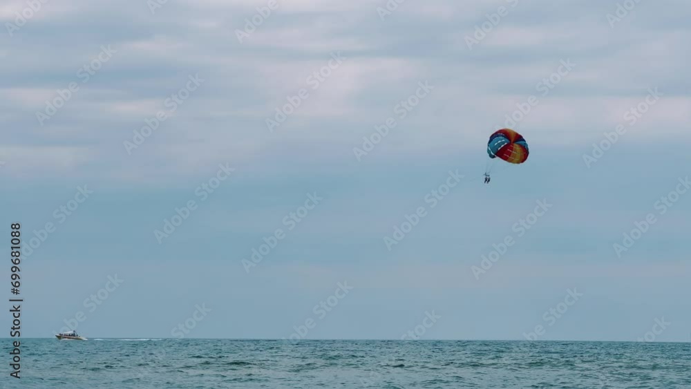 Parasailing: a boat with a marine parachute on the waves. The concept of a cloudy landscape, freedom and summer. Parachutists over the surface of the Black Sea against the sky on a summer day. 4K Parasailing: a boat with a marine parachute on the waves. The concept of a cloudy landscape, freedom and summer. Parachutists over the surface of the Black Sea against the sky on a summer day. 4K