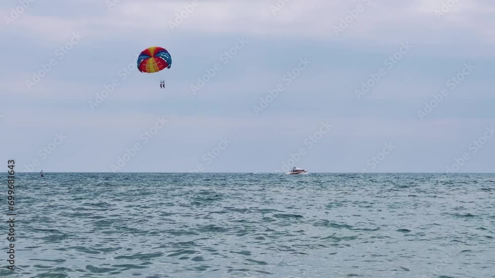 Parasailing: a boat with a marine parachute on the waves. The concept of a cloudy landscape, freedom and summer. Parachutists over the surface of the Black Sea against the sky on a summer day. 4K Parasailing: a boat with a marine parachute on the waves. The concept of a cloudy landscape, freedom and summer. Parachutists over the surface of the Black Sea against the sky on a summer day. 4K