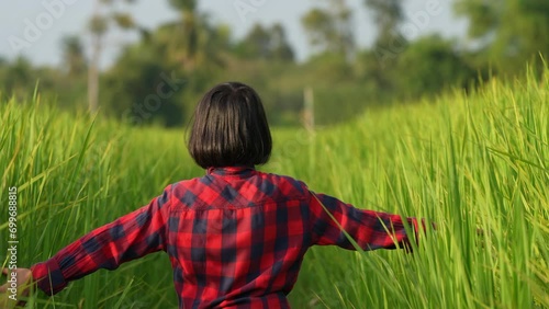 Young Girl in Rice Field: A young girl, lost in a vibrant rice field, explores the endless green landscape, representing the freedom of youth and the beauty of nature.
