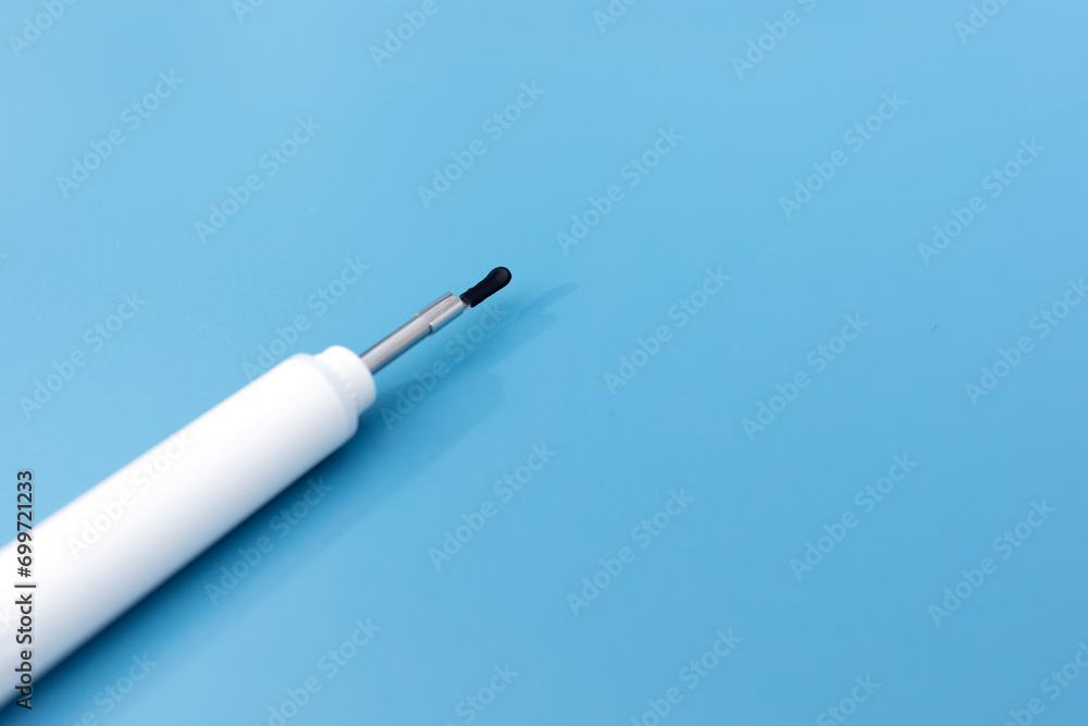 Naklejka premium Template Ear Scope For Wax Removal Tool on Blue Background. Digital Otoscope, Earwax Cleaner With Gyroscope, Camera, Light. Copy Space. Cleaning Ears Device Connected to Smartphone Technology
