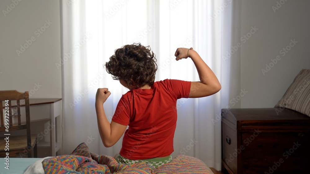 Boy Child 9 years old morning wake up in the morning in the home bed - he stretches and opens the window to start a new day of school - lifestyle in chilhood after finish of Coronavirus lockdown