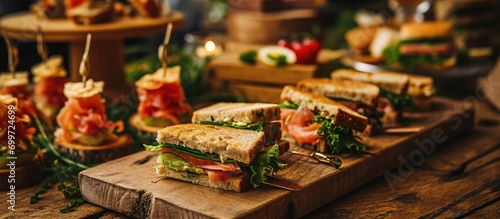 Tasty finger food spread with smoked salmon sandwiches, chicken and lettuce sandwich quarters.