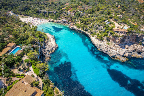 Aerial view with Cala Llombards secluded shores, where crystal-clear waters and golden sands create a peaceful haven on Mallorca coast. photo