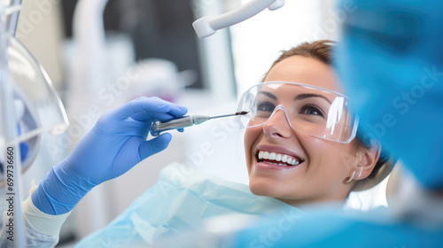 Young woman with a bright smile is in a dental chair during an examination photo