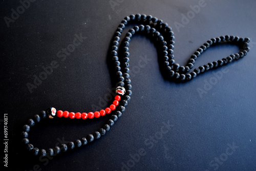 black and red beaded necklace on a black surface