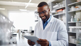 Smiling male scientist with curly hair and glasses is holding a tablet and standing in a modern laboratory