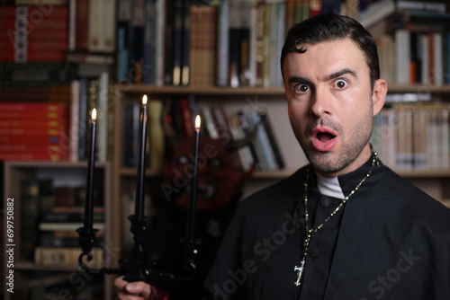 Priest holding a candelabra with spooky demon in the background photo