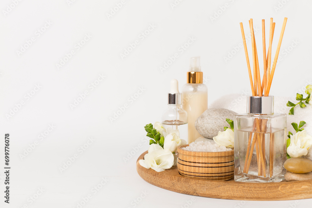 Spa composition with freesia flower and aroma diffuser on white background Spa composition with freesia flower and aroma diffuser on white background