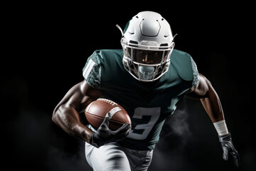Portrait of American football player running with the ball. Muscular African American athlete in a green and white uniform with an ovoid ball in a dynamic pose. Isolated on black background.