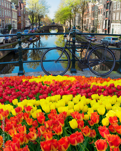 Canvas Print bicycle standing on the bridge next to canal in Amsterdam, Netherlands