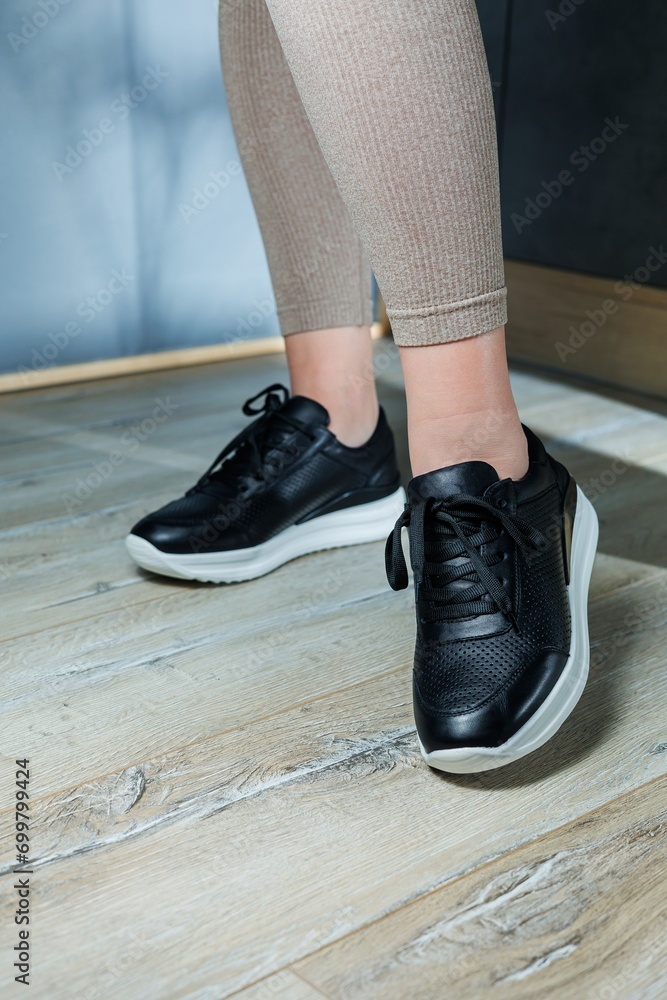 Black women's sneakers. Collection of women's leather shoes. Female legs in leather black casual sneakers. Stylish women's sneakers. Black women's sneakers. Collection of women's leather shoes. Female legs in leather black casual sneakers. Stylish women's sneakers.