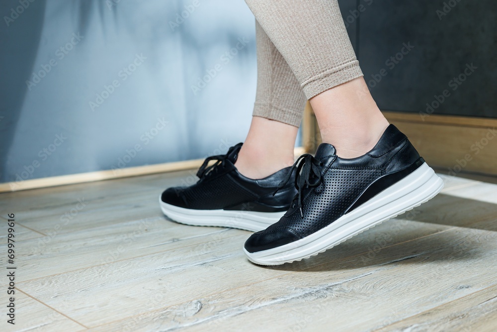 Black women's sneakers. Collection of women's leather shoes. Female legs in leather black casual sneakers. Stylish women's sneakers. Black women's sneakers. Collection of women's leather shoes. Female legs in leather black casual sneakers. Stylish women's sneakers.
