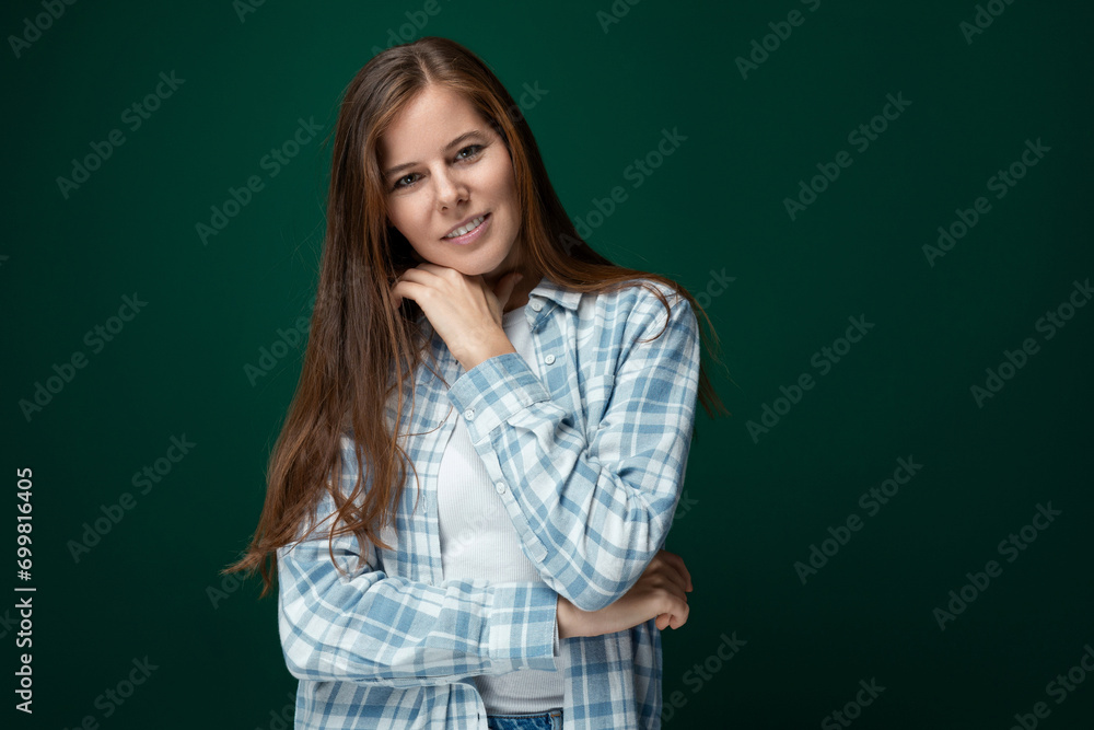 Confident Caucasian young woman stands in a leader's pose on a green studio background Confident Caucasian young woman stands in a leader's pose on a green studio background