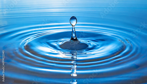 Water drop falling on blue water and splashing