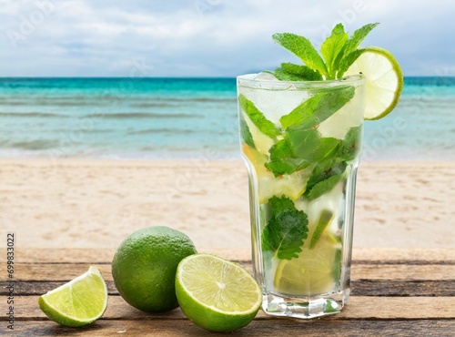 ''Mojito'' cocktail isolated on wooden table, with the beach on the background. Resort bar on the beach. 