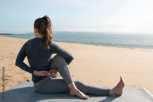Young woman practicing yoga on the beach. Concept of healthy lifestyle and relaxation. © Elena