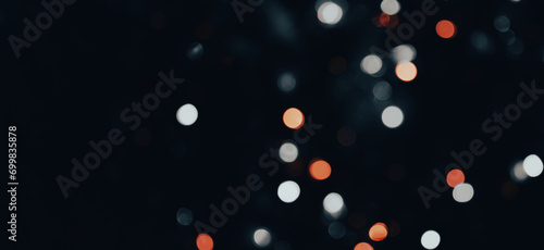 dark backdrop with a multicolored bokeh effect from scattered, out-of-focus light spots