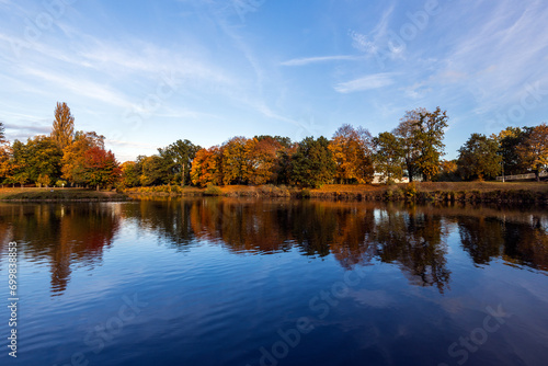 Autumn landscape with colorful trees and lake in the city park.