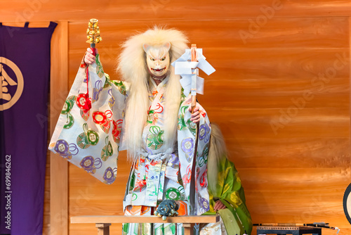 Kagura dance performed by the Inari fox deity holding suzu bells and a gohei wand which have the power to exorcise and purify evil spirits during the Konpira festival of Toranomon Kotohiragu shrine.