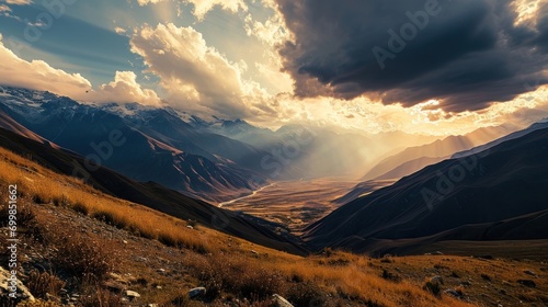 A panoramic view of a mountain range with dramatic clouds and sunset.