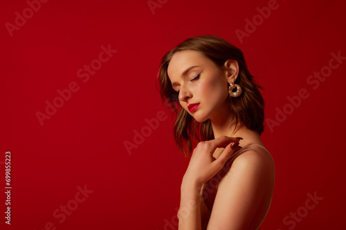 Wallpaper Mural Young beautiful woman with red lips makeup wearing trendy pearl earrings, posing on red background. Close up studio portrait. Copy, empty space for text Torontodigital.ca