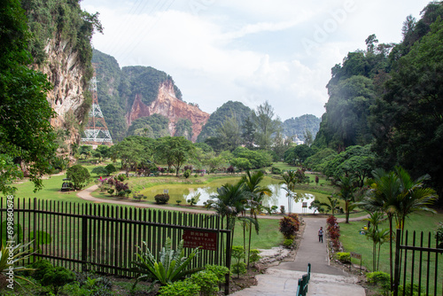 Картината върху платно A tranquil park with lush greenery and a rugged mountain backdrop