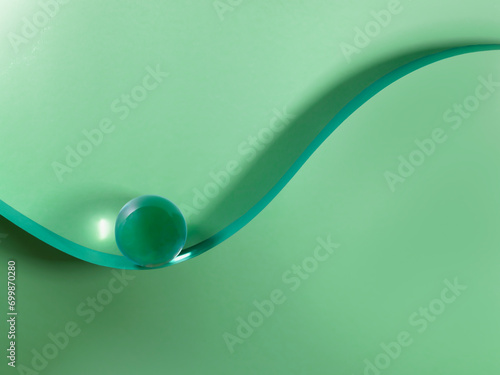 Glass sphere on a sigmoid curve against a green background photo