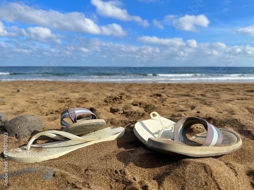 Close-up of two pairs of flip flops on La Garita Beach, Arrieta, Las Palmas, Lanzarote, Canary Islands, Spain photo