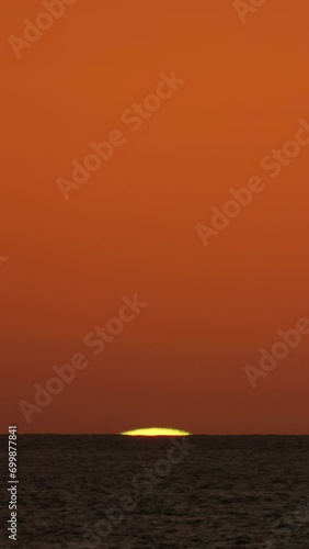 Big sun rising over the ocean water time lapse, zoom view from the coast beach, beautiful nature background timelapse, clear sky