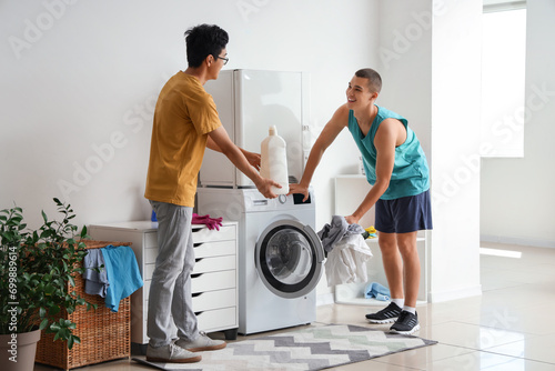Male students doing laundry in dormitory photo
