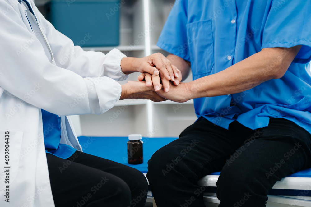 © laddawan - Asian doctor in white suit take notes while discussing and Asian elderly, man patient who lying on bed with receiving saline solution
